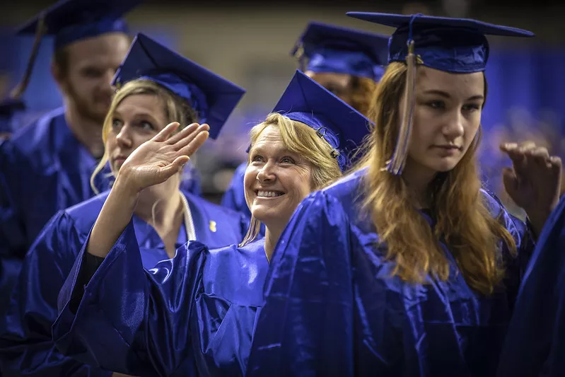 Female Graduate Smiling and Waving