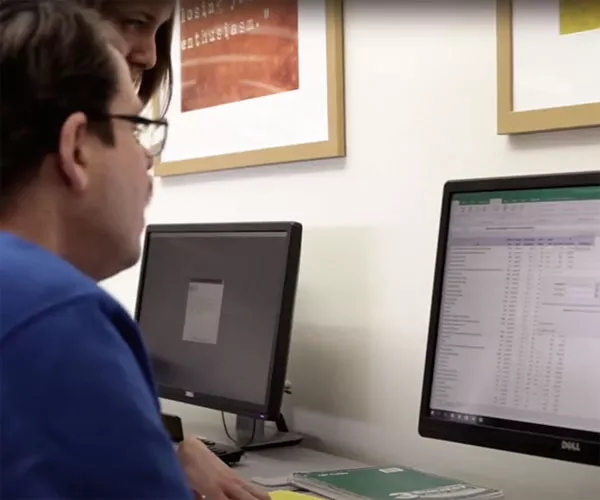 account student and instructor working on a project in MS Excel