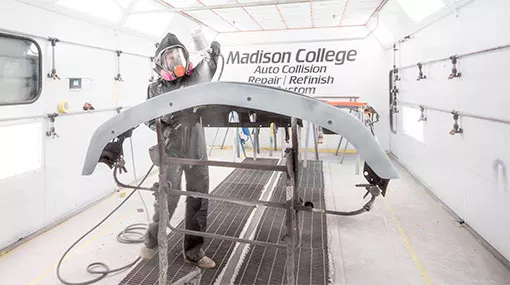 auto collision student painting a car fender