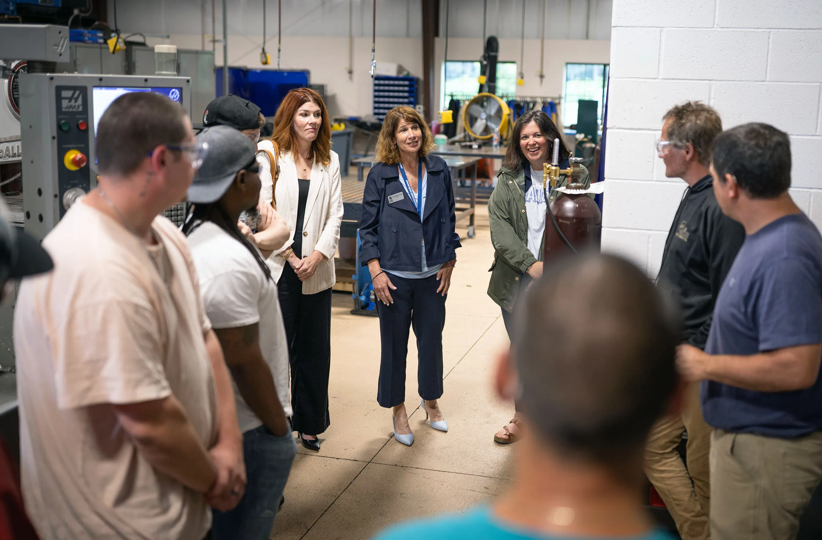 President Berne standing at a welding lab at the Fort Atkinson campus, talking with students and staff.