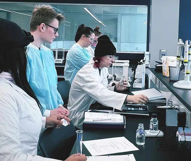 biotechnology students in collaborating in lab