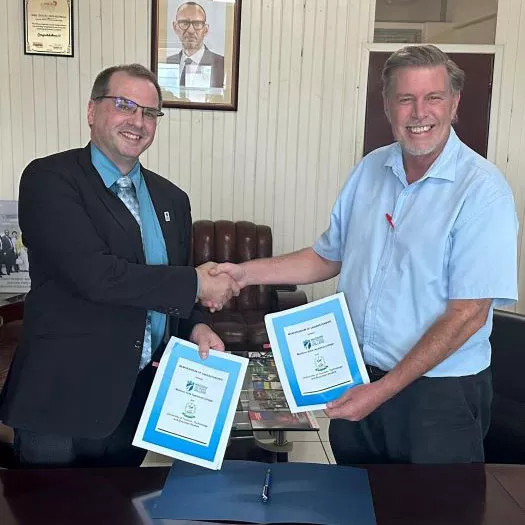 Dr. Geoff Bradshaw and Vice Chancellor, Simeon Wiehler share signed MOU agreements between Madison College and the University of Tourism, Technology and Business Studies.