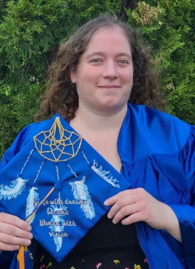 Brittany holds her decorated graduation cap