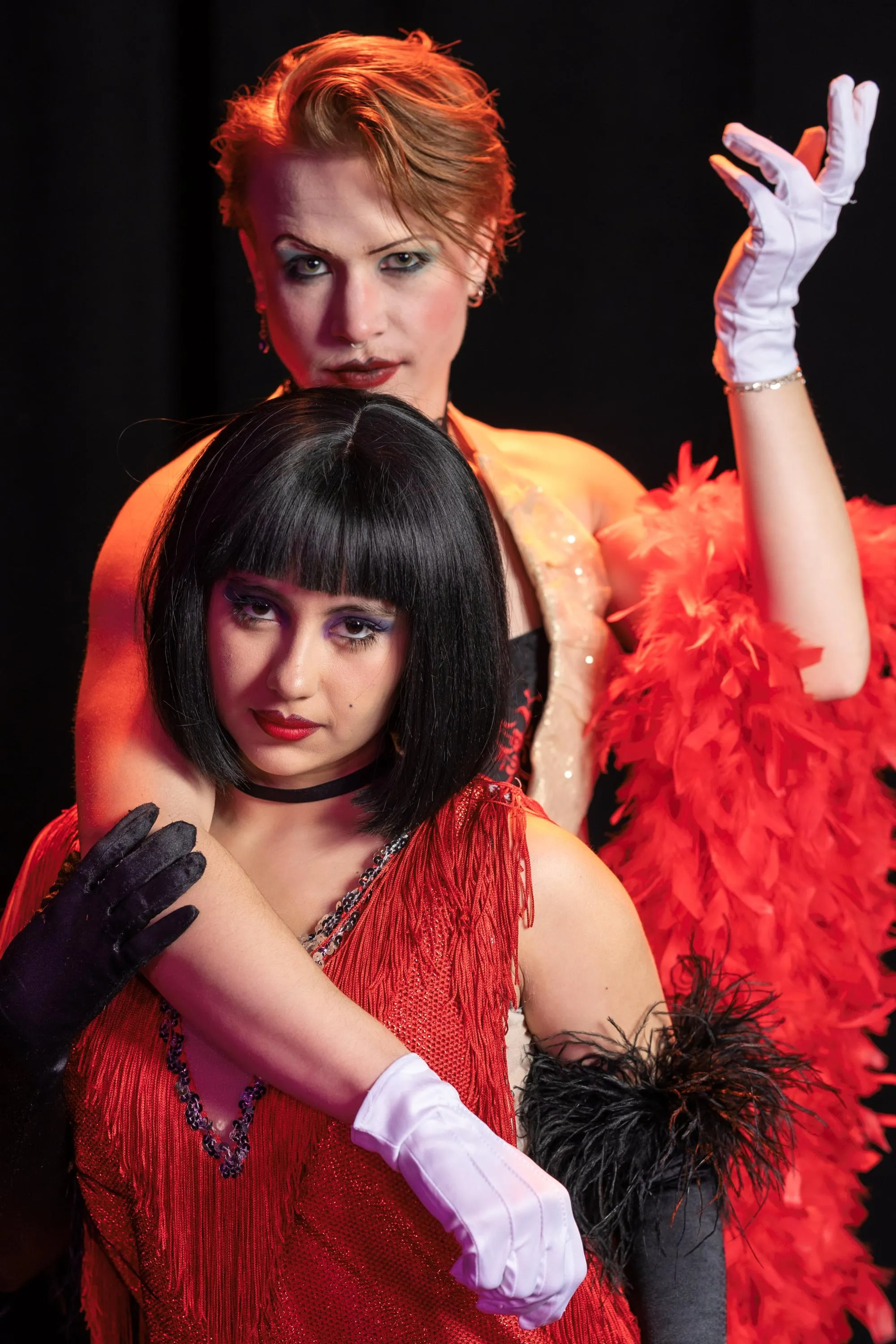 Cabaret performers in red and black costumes