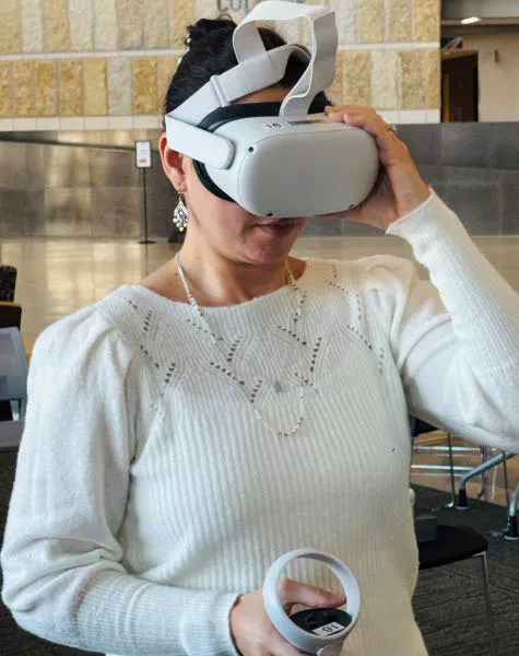 Madison College Spanish instructor Carolina Bailey demonstrates the VR equipment