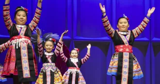 Hmong children dancers performing on stage.