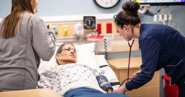 Nursing students work on a dummy patient at the Watertown campus.