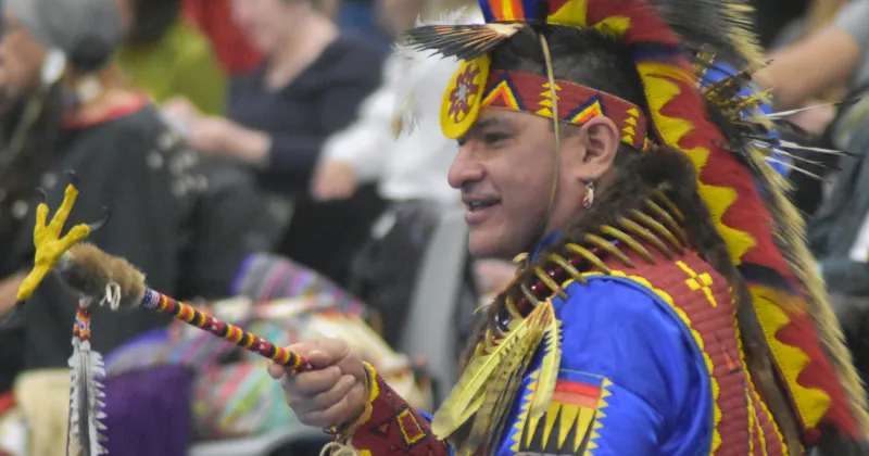 Photo of pow wow dancer with feathers and beaded outfit.