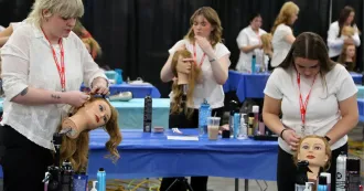 Students compete in the 2025 SkillsUSA cosmetology, styling and cutting the hair of plastic dummies.