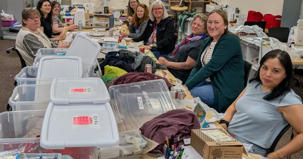 Image of students in the fabric arts program sewing zippers into manikin clothes.