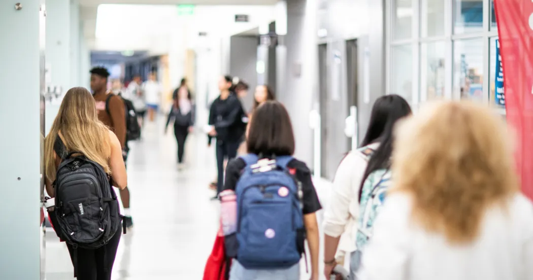 Image of students walking down a hallway. Many start at Madison College then transfer to earn bachelor's degrees