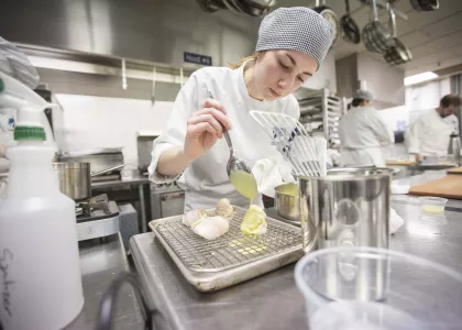 student putting sauce on food