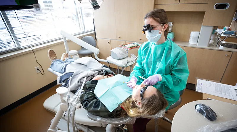 Dental Hygiene student cleaning a patient's teeth in our clinic