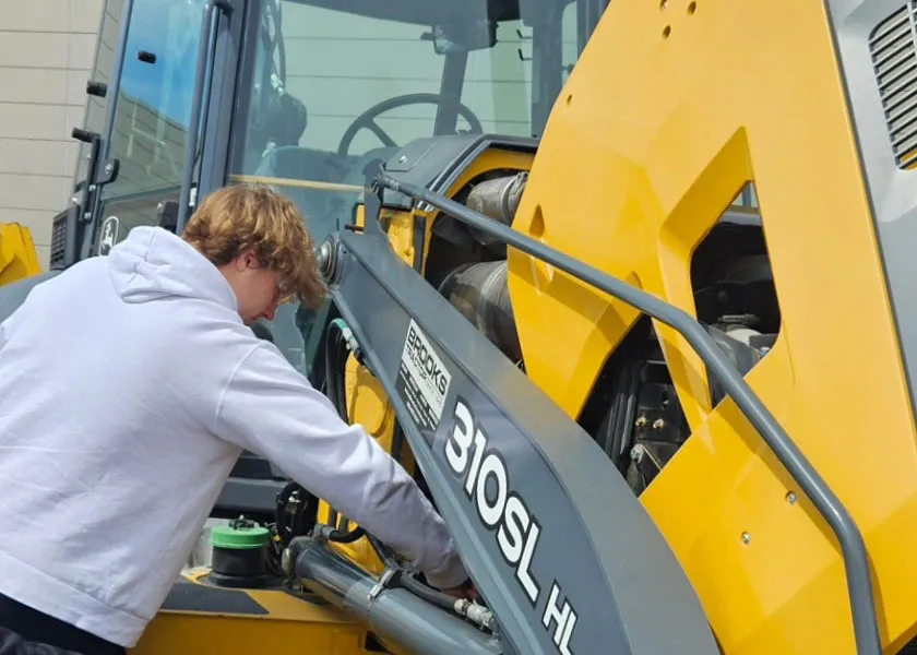 Diesel Heavy Equipment student working on a John Deere backhoe loader
