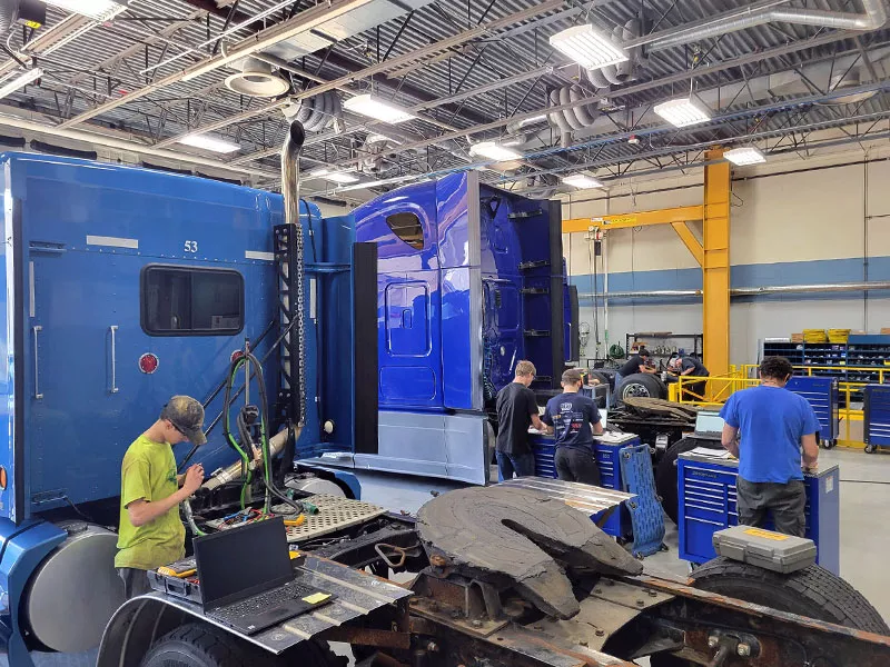 medium and heavy diesel students working on semi trucks in lab