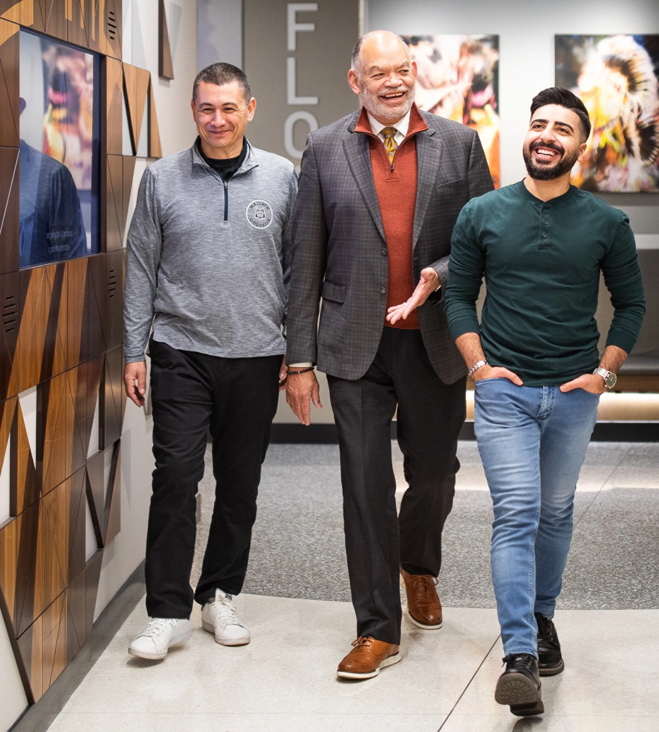 President Daniels walking with students and faculty in the halls of Goodman South campus.