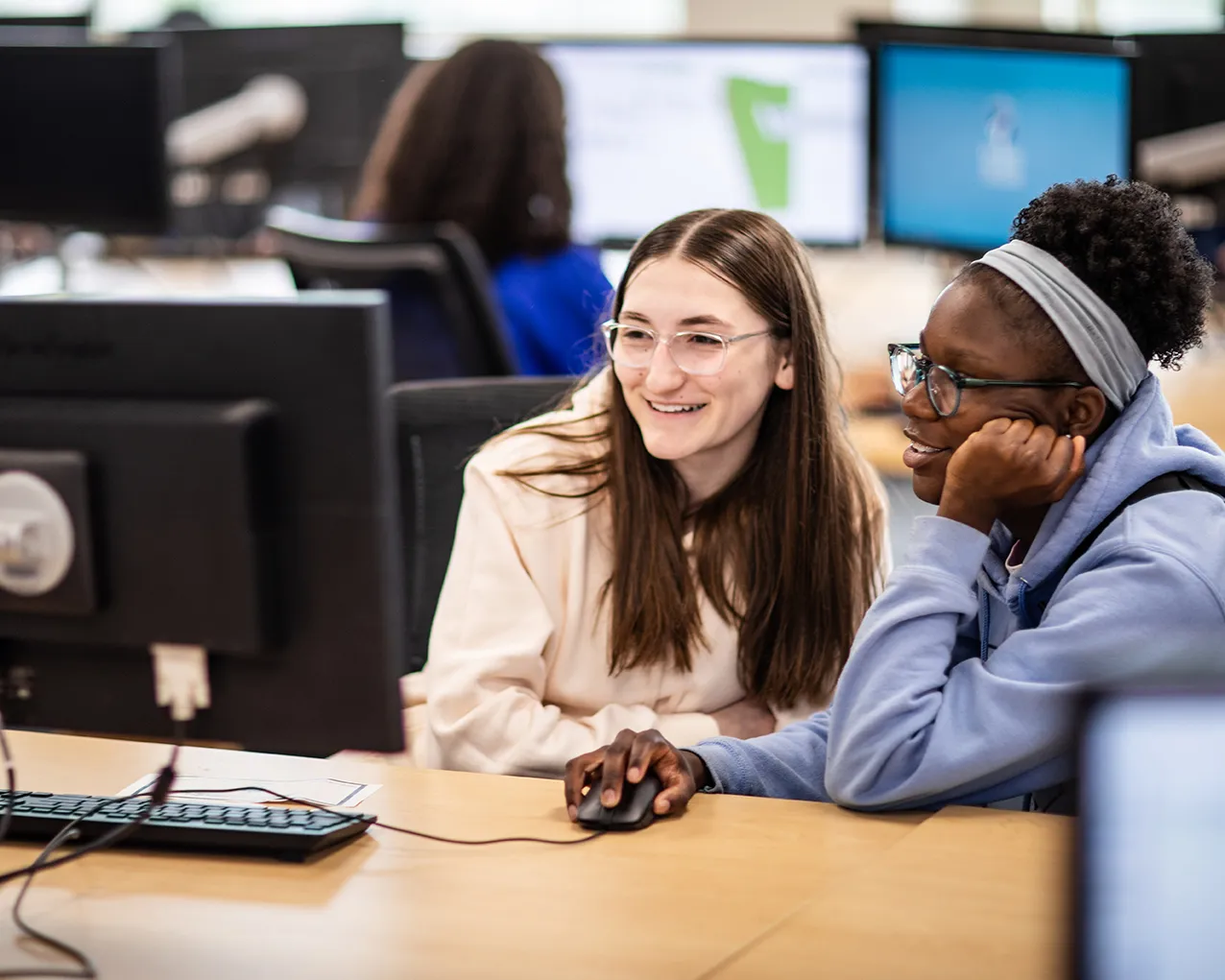 two students looking at a desktop computer monitor