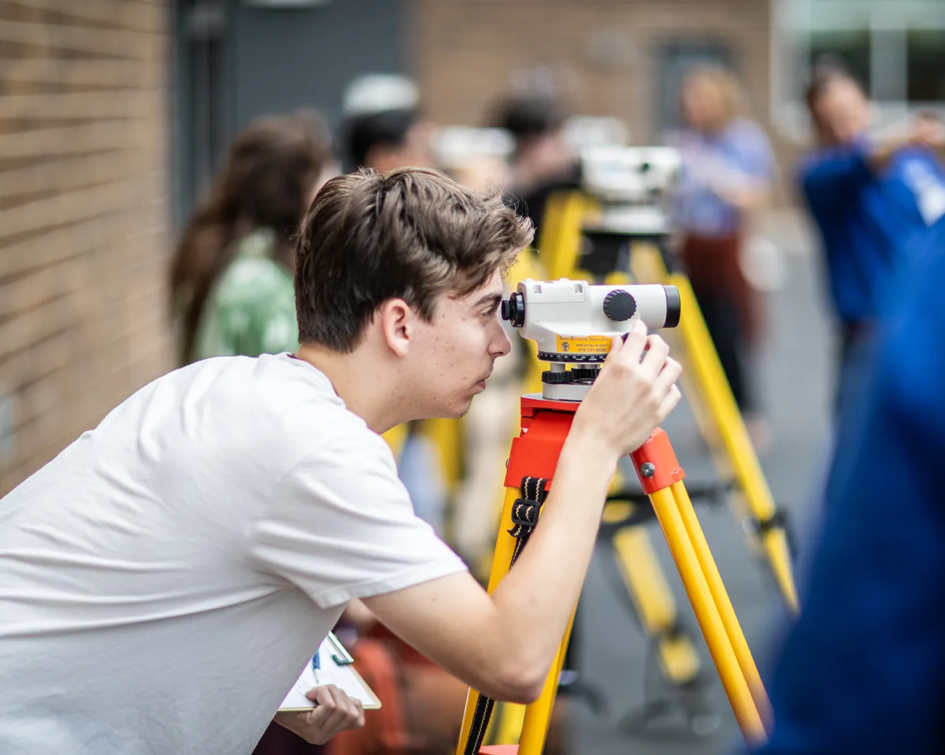 student looking through surveyor equipment
