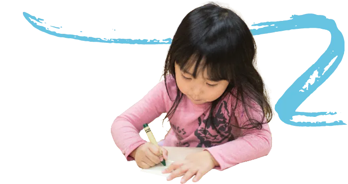 A child coloring at a table in a child care center