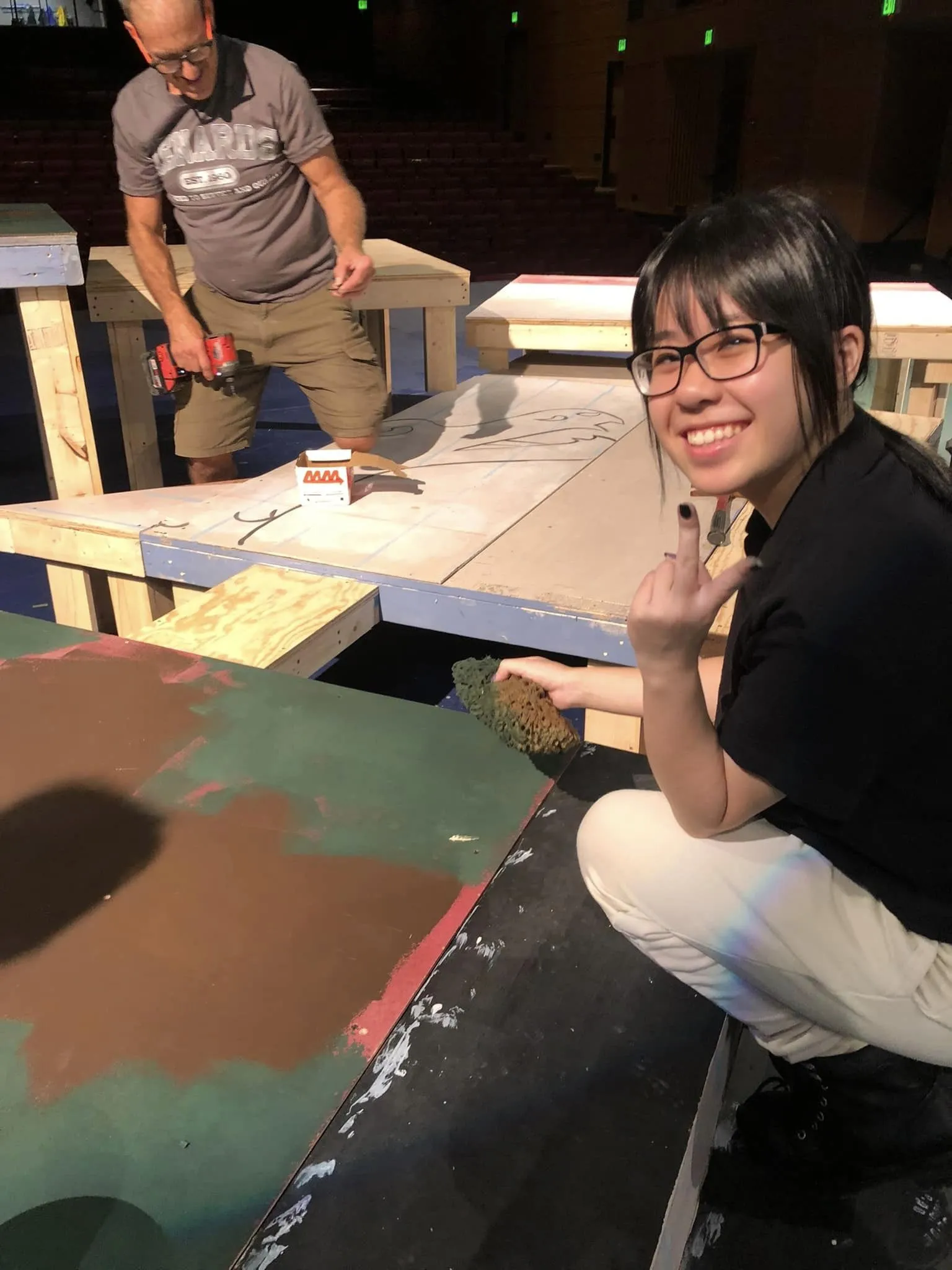 A student works with a master carpenter on the Women of Lockerbie set