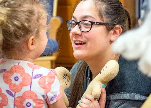 education student interacting with a toddler