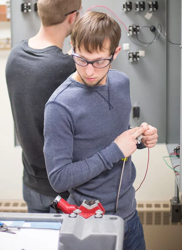 student working with electrical equipment in lab