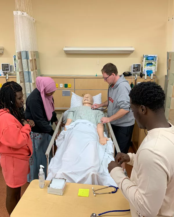 Madison College healthcare students practicing on a patient mannequin