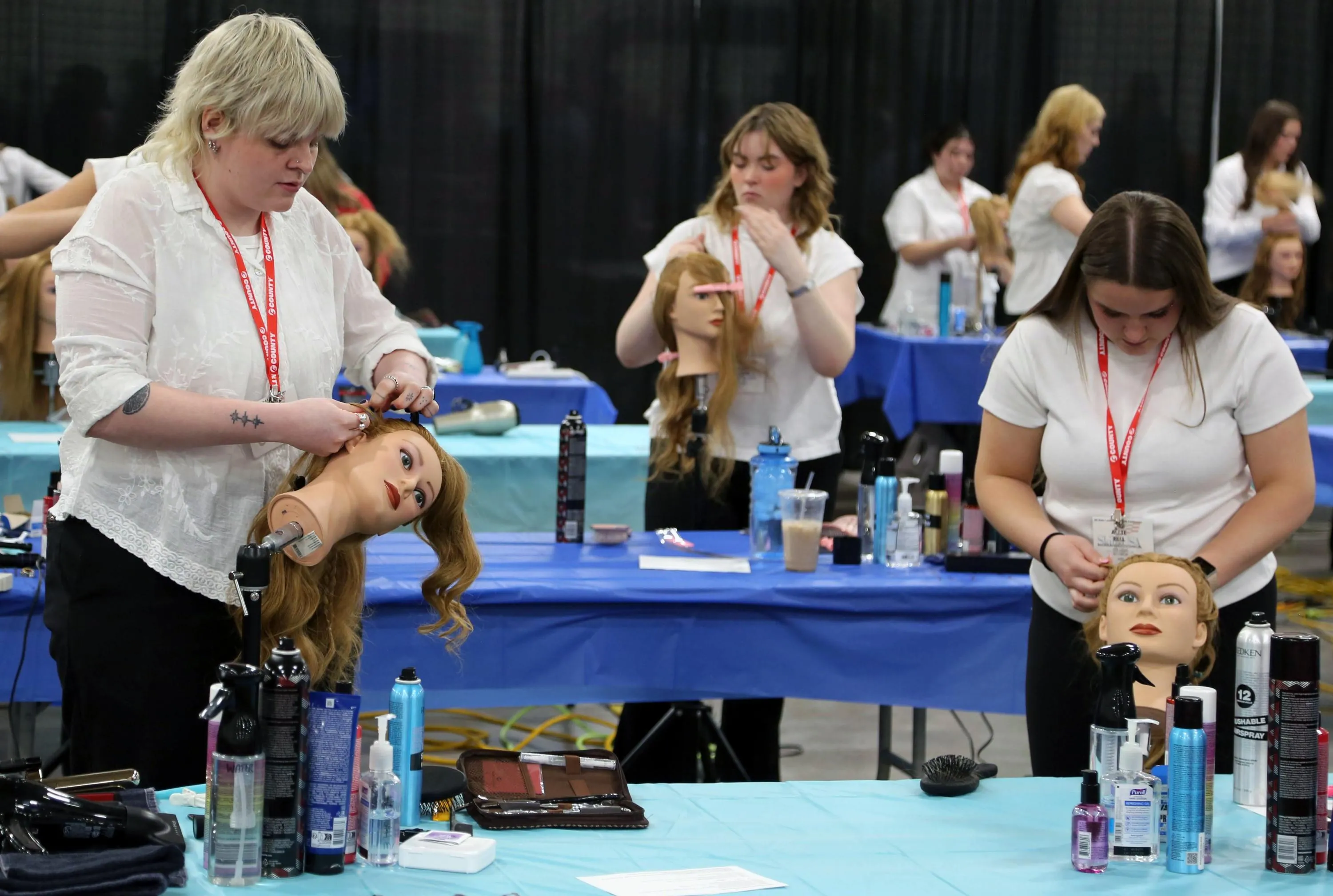 Students competing in the SkillsUSA cosmetology competition. Students are styling the hair of dummy models.