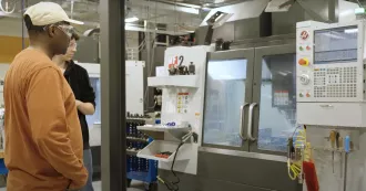 manufacturing students working with a CNC machine