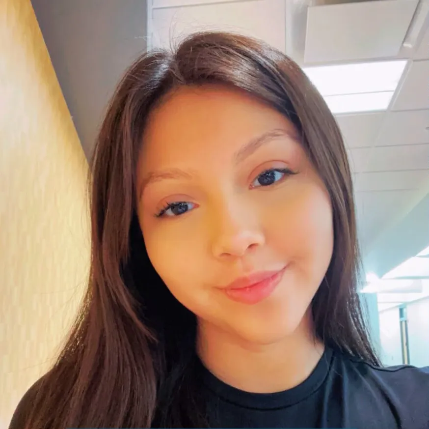 Headshot of Jackalyn. Dark hair, eyes and shirt. 