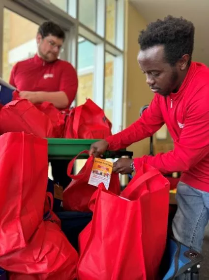 Madison College Peer Health students Janvier Mukunzi and Jackson help distribute bags of the food.