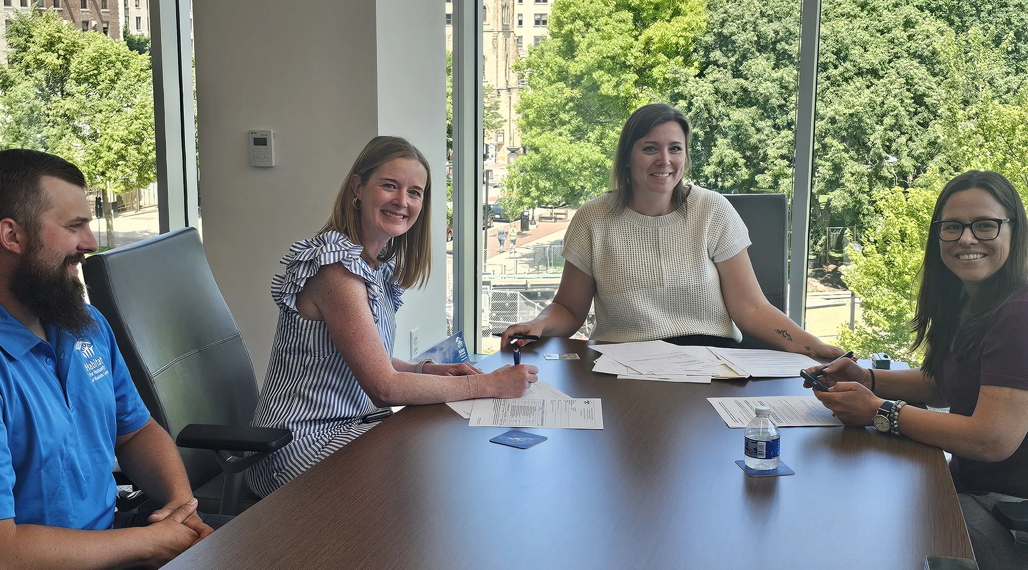 Image of Madison College staff and Habitat for Humanity signing closing documents for land purchase. 