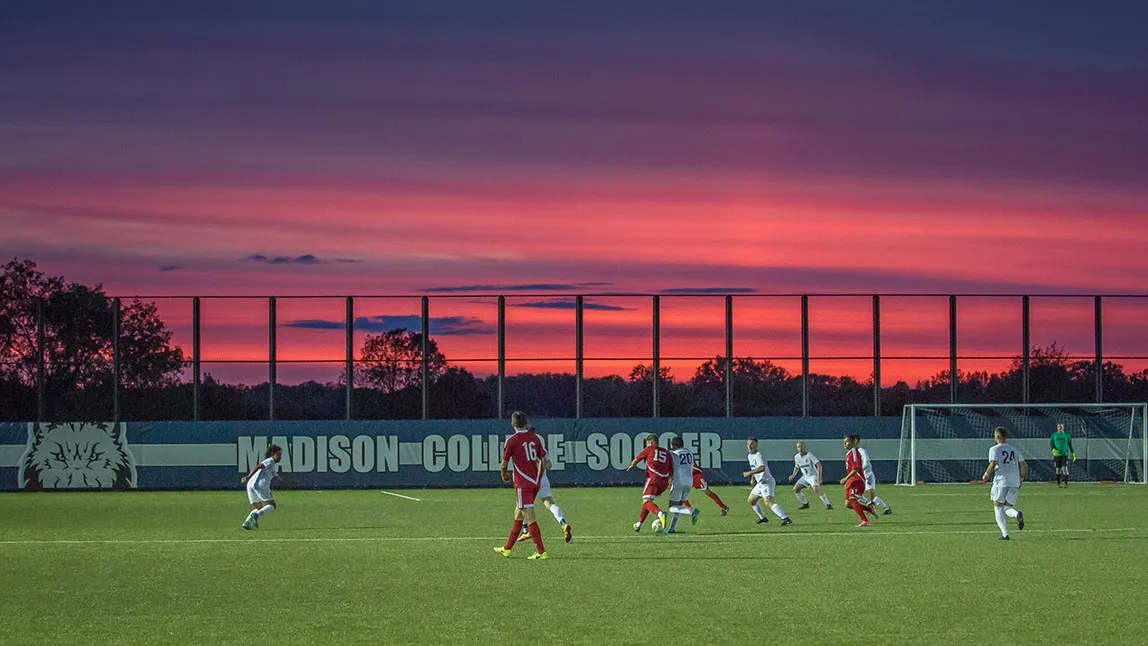 Men's soccer team playing a home game during sunset