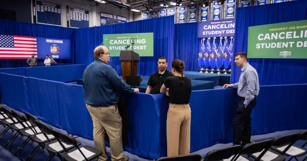 Four people talking around blue pipe and drape