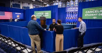 Four people talking around blue pipe and drape