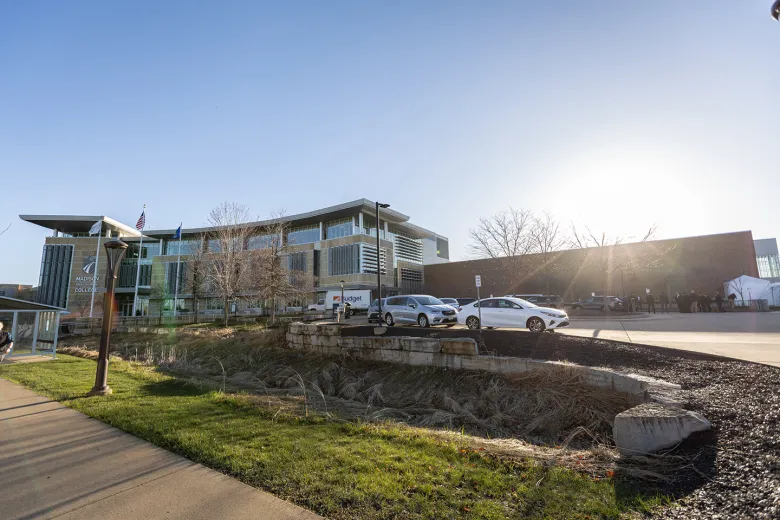 Lime stone building with madison college logo. A storage truch with the word budget on it is in front.