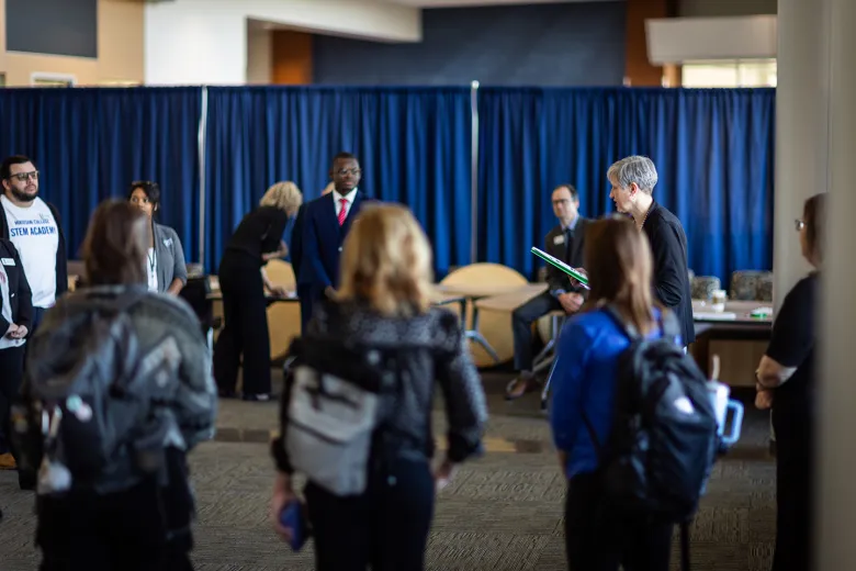 People waiting around a blue curtain