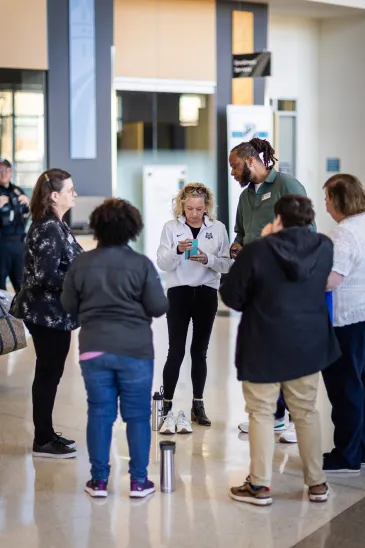 Six poeple standing in a circle with a security guard in background
