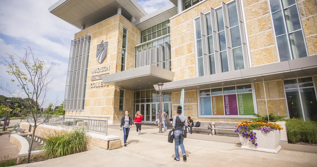 Outside view of Gateway entrance at the Traux campus, with students walking toward doors.