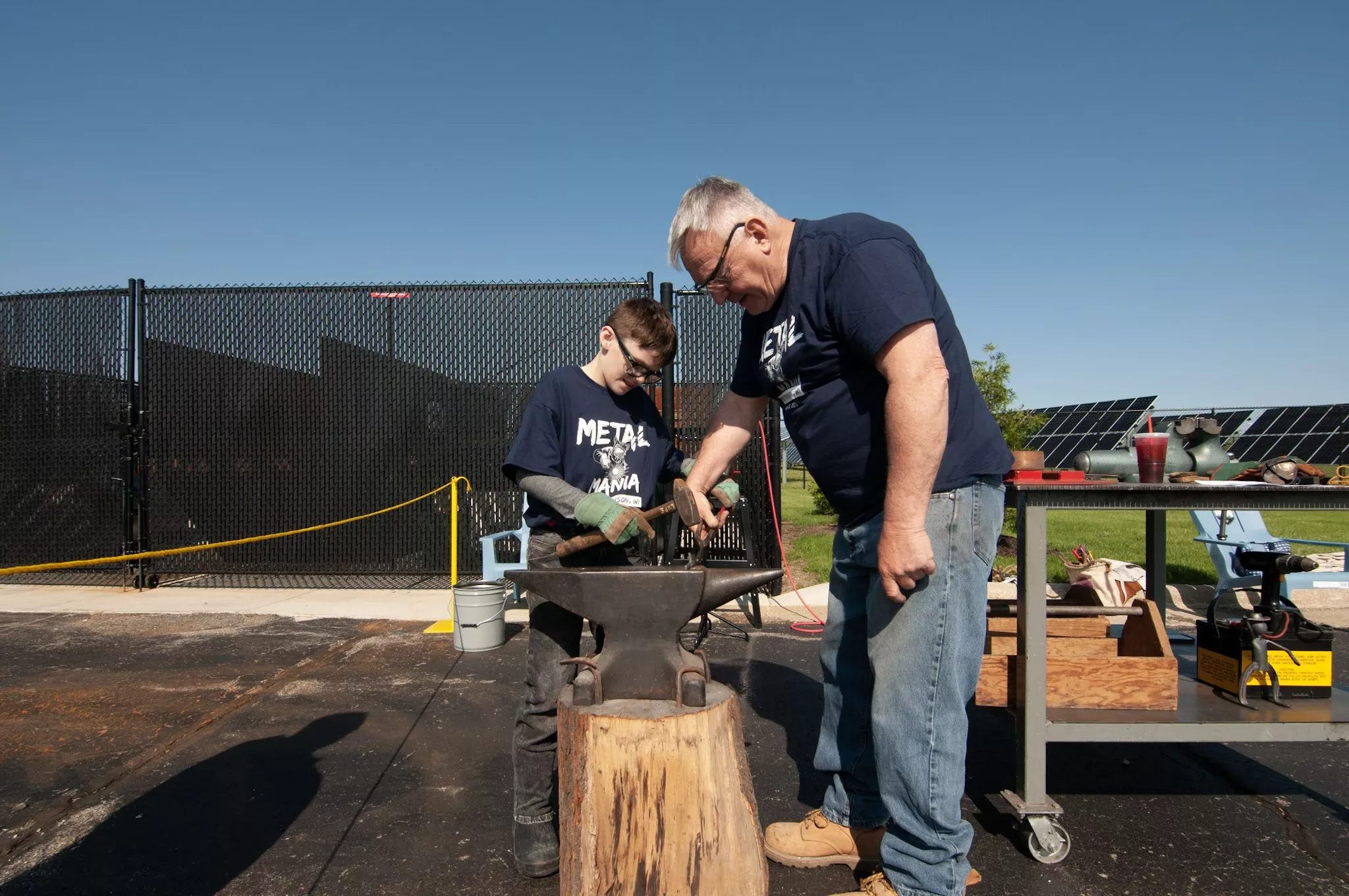 Man and kid using metal fabrication tools