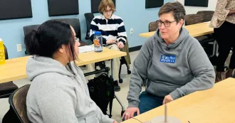 WTCS President Dr. Morna Foy talks with students in the classroom.