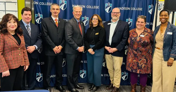 Madison College and MSOE leaders pose before a Madison College banner following the transfer agreement signing.