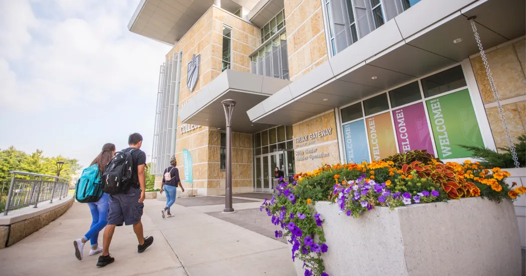 Photo of three students walking into the Gateway entrance of Madison College Truax campus.