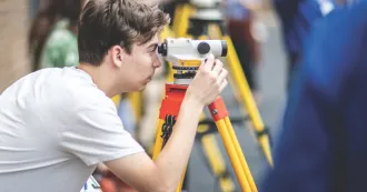 Image of student using a surveying tool. 