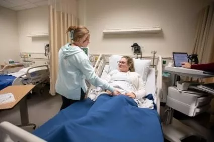A Madison College nursing student working with a patient