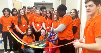 Students cutting a ribon at Mini Manufacturing World