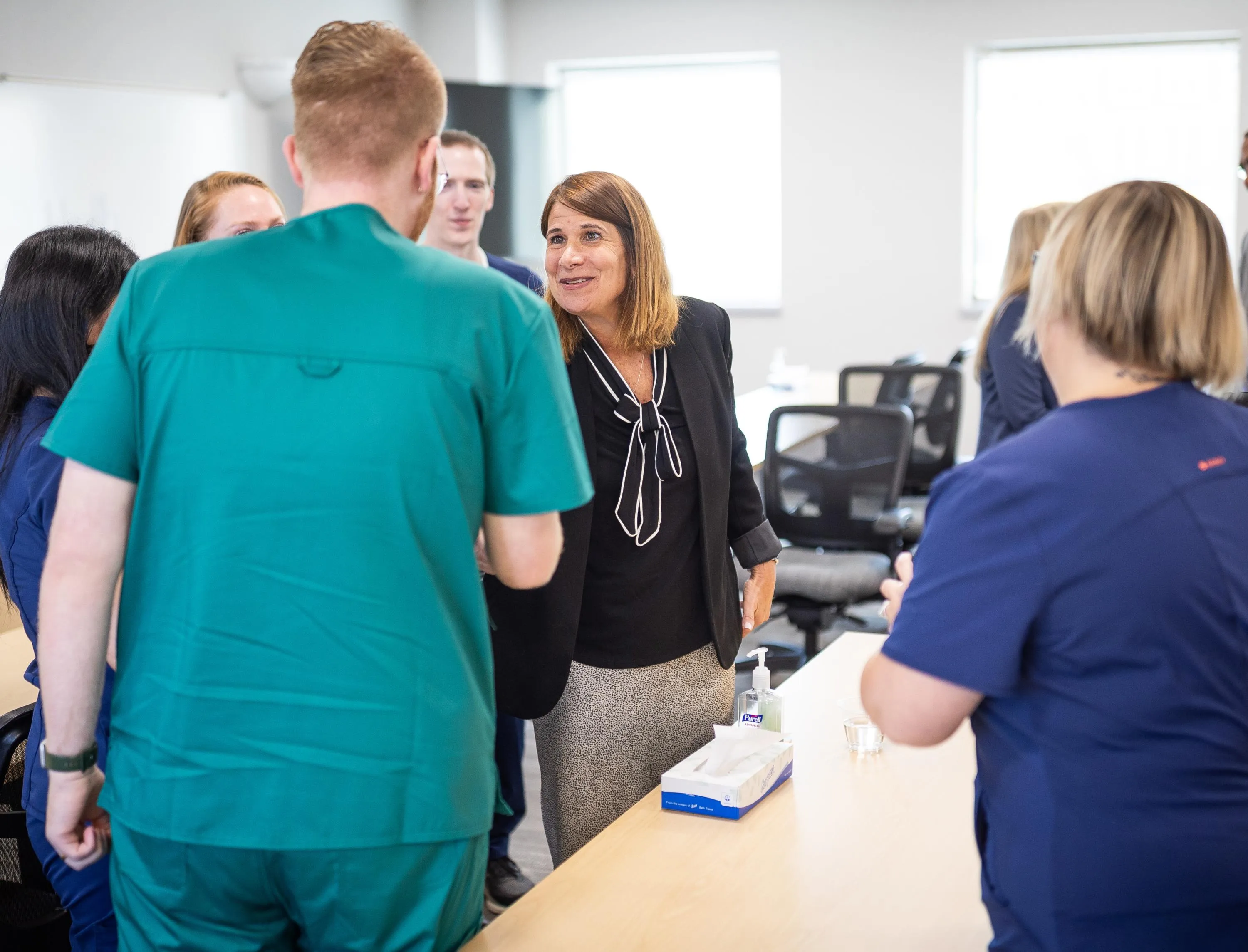 Madison College President Jennifer Berne shakes hands with a student in the surgical technologist apprenticeship program