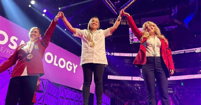 three winners holding their hands up