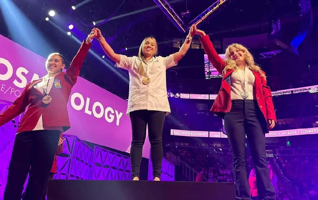 three skills usa winners holding their hands up in victory