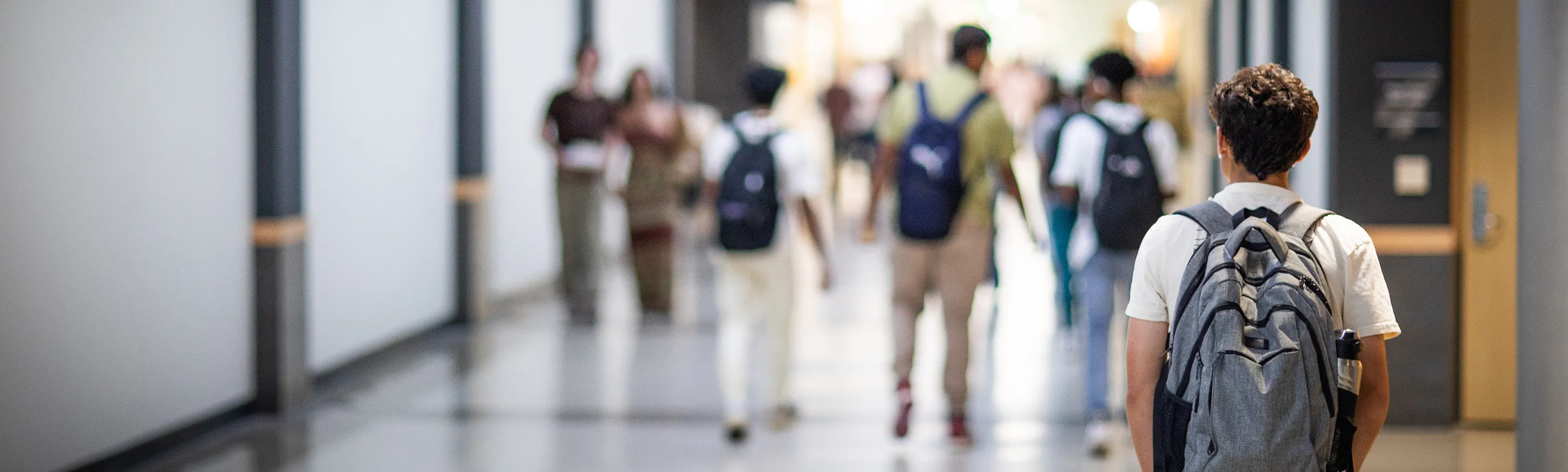 student wearing backpack facing away from camera
